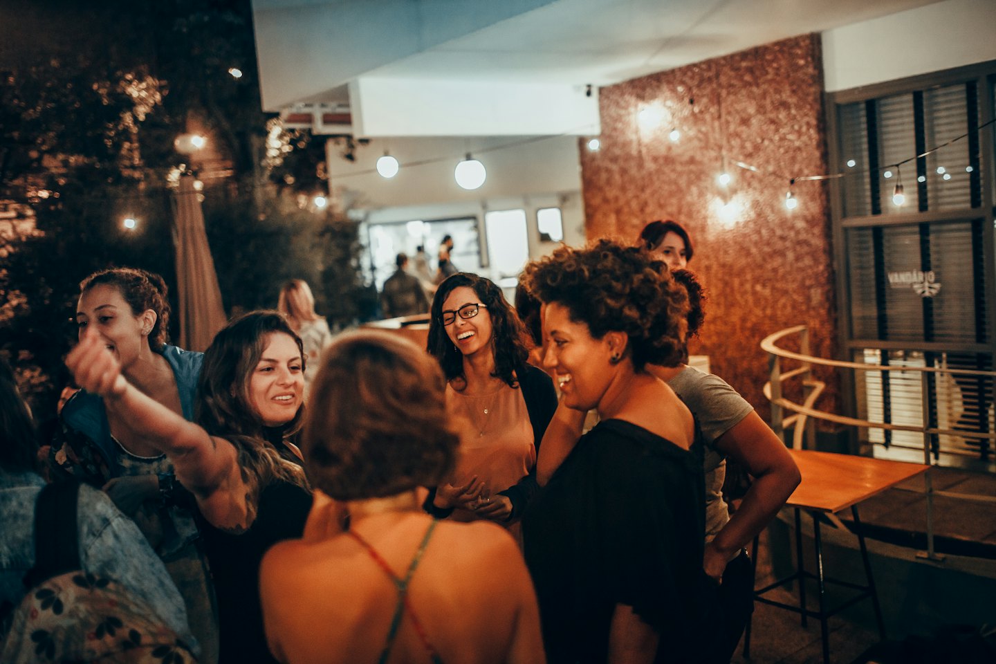 Eine Gruppe von Frauen, die sich bei einer Feier im Freien unterhalten und lachen.