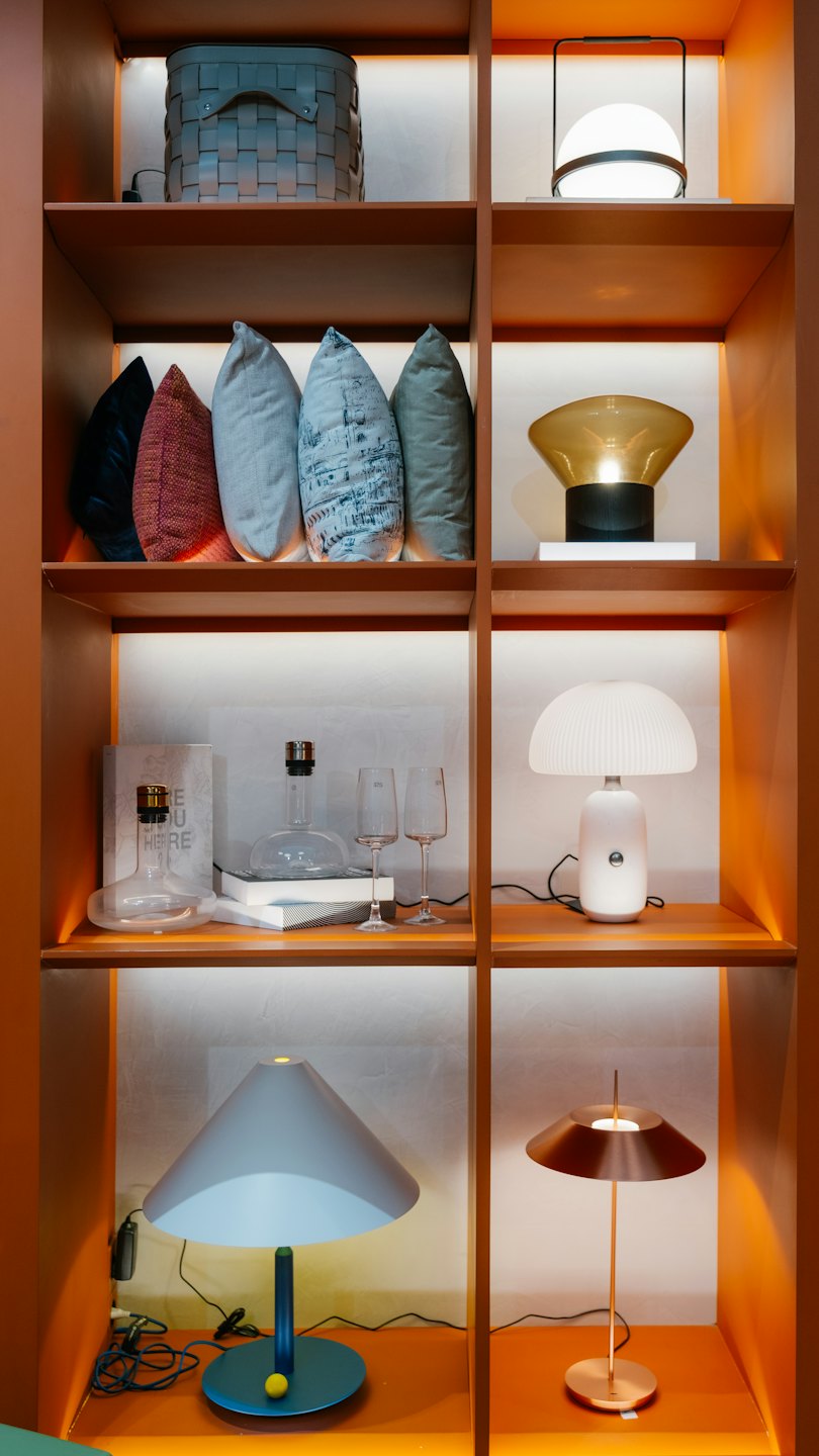 Moderne Wohnaccessoires auf beleuchteten Holzregalen.